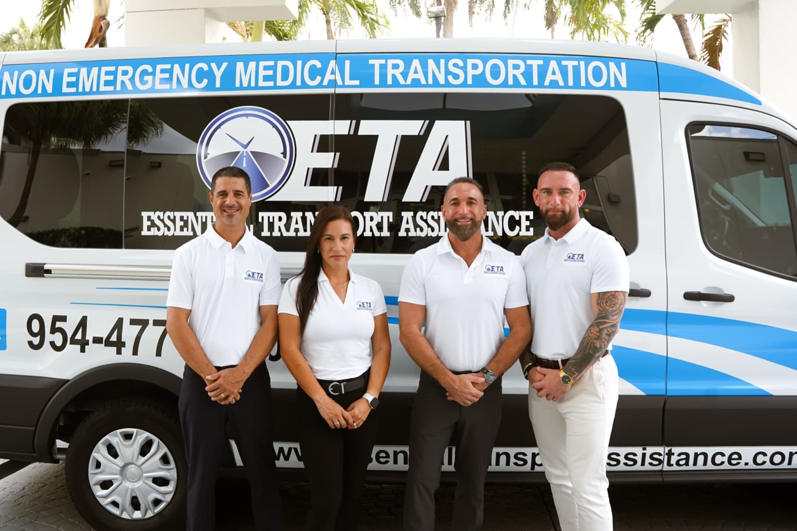 The family-owned Essential Transport Assistance team in branded uniforms in front of their medical transport van